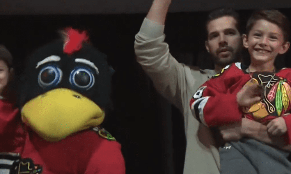 Corey Crawford sounds the horn with his sons at the Blackhawks vs Wild game on Nov. 10, 2024.